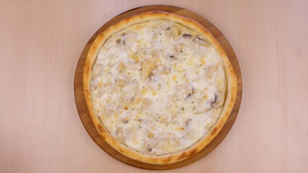 Pizza with mushrooms champignons and cheese on wooden board on the table. Close-up top view. — Stock Video