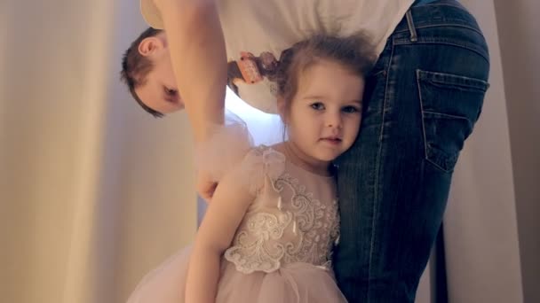 Papa is koppelverkoop dochters jurk. Klein meisje in een mooie jurk. — Stockvideo