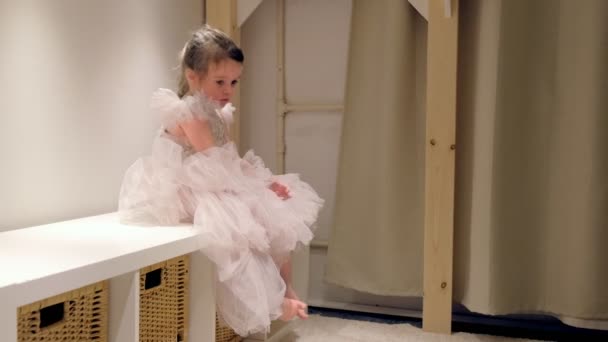 Маленькая девочка в красивом платье сидит расстроенная в своей комнате . — стоковое видео