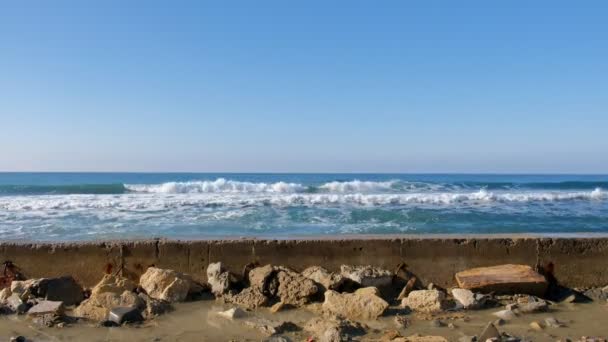 Бризки води з бурхливої хвиль на breakwater на набережній, буря моря, хвилі і гуркотом об скелі під Синє небо. — стокове відео