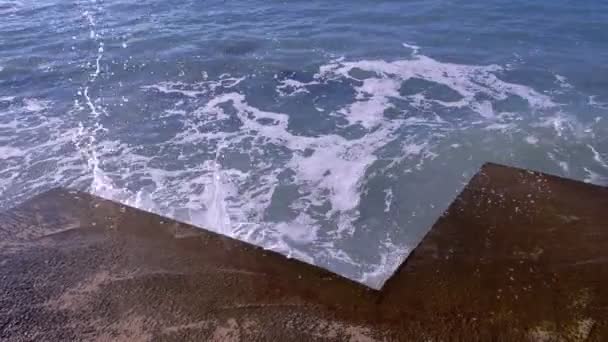 Splashes de água das ondas tempestuosas que quebram no quebra-mar em beira-mar. Vista superior . — Vídeo de Stock