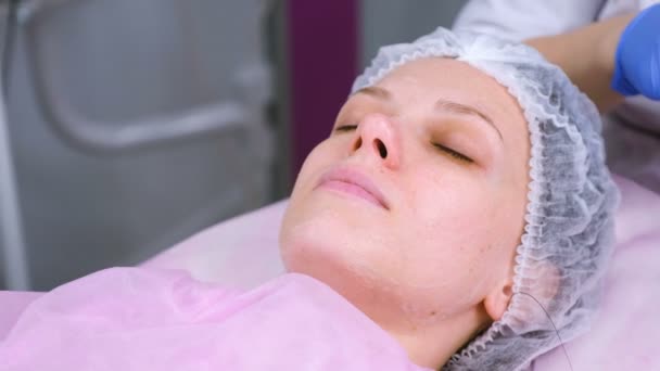 Beautician lava la cara de las mujeres usando almohadillas de algodón. Preparación para una cara de limpieza . — Vídeo de stock