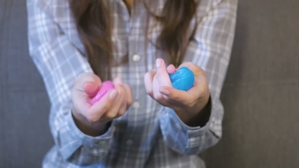 Twee slimes roze en blauw in handen van de dames. Spelen met slijm. — Stockvideo