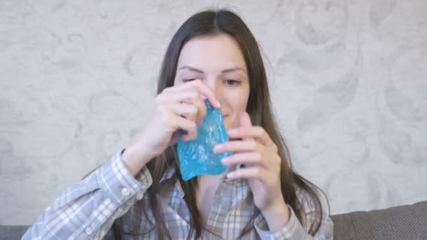 Vrouw is uitrekken zich een blauwe slime zittend op de coach en spelen. Kijkend naar de slime. — Stockvideo