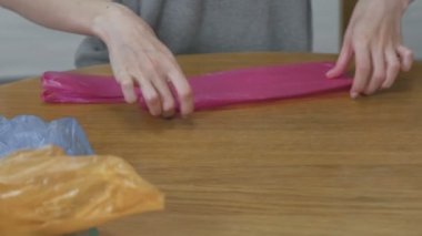 Kadın dikkatle plastik torbalar yeniden kullanmak üzere pas geçiyor. Yakın çekim yakışıklı.