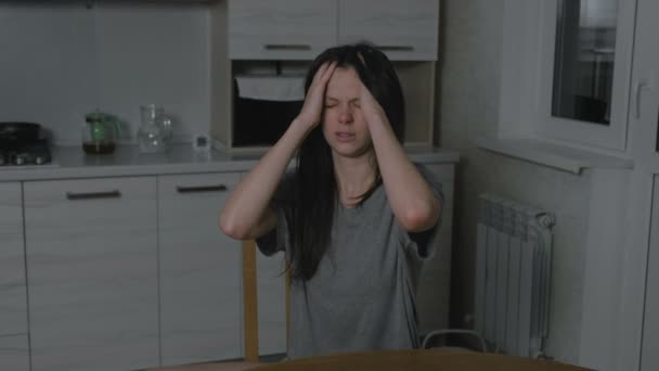 Kobieta z bólem głowy w kuchni w nocy. Bezsenność i depresja. — Wideo stockowe