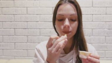 Kafede peynir soslu patates kızartması yiyen kadın.