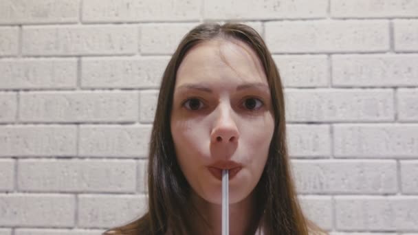 Sorrindo mulher bonita está bebendo uma bebida de um tubo . — Vídeo de Stock