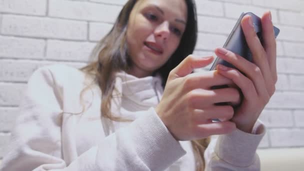 Улыбающаяся женщина печатает сообщение на мобильном телефоне сидя и ожидая кого-то в кафе . — стоковое видео