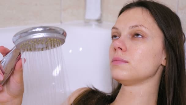 Woman is taking a bath. She pours her body water from the shower. Close-up face. — Stock Video