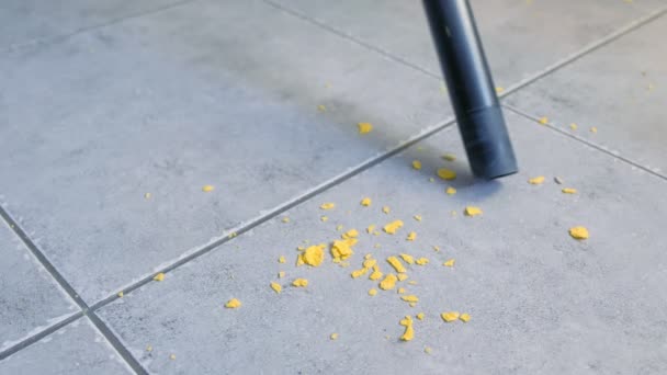 Vacuuming the kitchen floor with grey tile without brush, only pipe of vacuum cleaner. Close-up view. — Stock Video