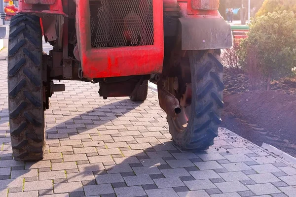 Traktor på trottoaren i staden, gas från avgasröret. — Stockfoto