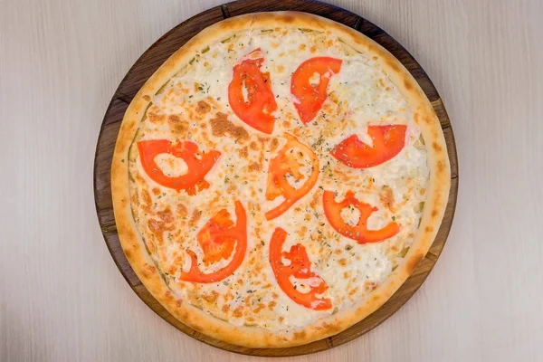 Pizza paradicsommal és sajttal, fából készült táblán. Szemközti nézet. — Stock Fotó