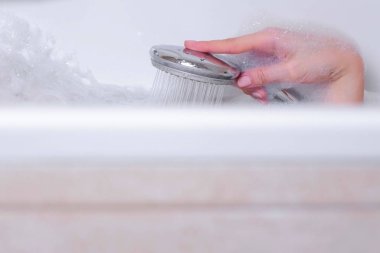 Kadın köpüklü bir duş alıyor. O vücudu duş su dökülen. El yakın çekim.