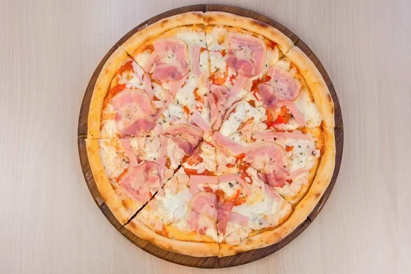 Pizza a szalonna és a sajt, fából készült táblán az asztalon. Közeli kép: felülnézet. — Stock Fotó