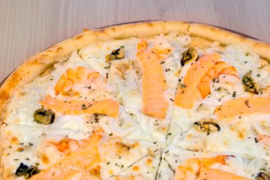 Deniz ürünleri ve peynir, yakından görmek pizza Dilimleme yarısı.