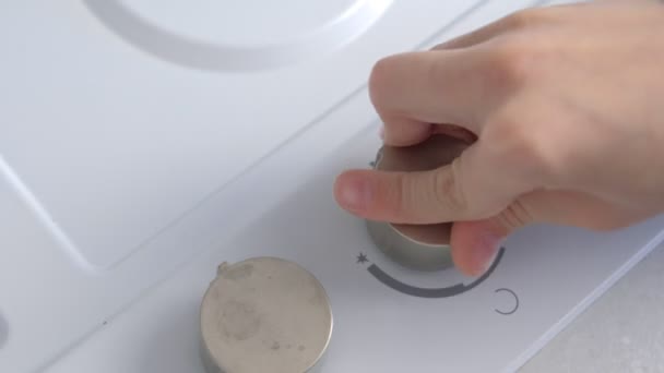 Criança pressiona o interruptor rotativo com um esforço para ligar o fogão a gás . — Vídeo de Stock