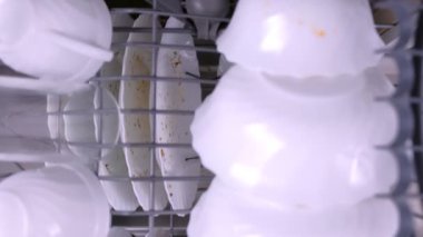 Mans el kirli bulaşıkları ile bulaşık makinesi sepetleri iter.