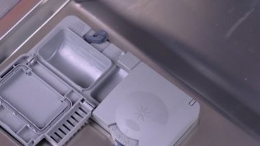 Mans el bulaşık makinesi otomatik bölmesine deterjan tablet koyarak.