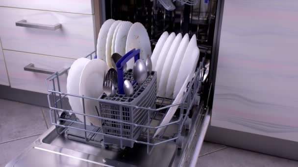 Cesta para lavavajillas con platos blancos sucios y cubiertos en la cocina . — Vídeo de stock