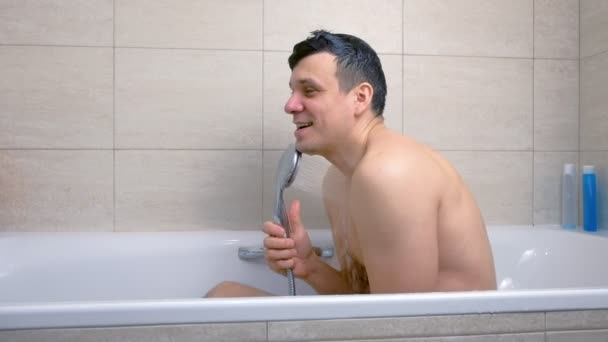 El hombre feliz está cantando mientras se lava en la bañera . — Vídeo de stock