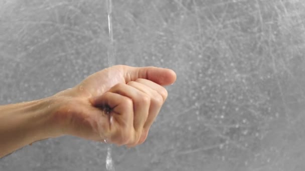 Water flows through the mans hand. Man clenches his hand into a fist. Hand close-up. — Stock Video