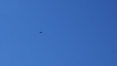 Helikopter mavi gökyüzünde yüksek uçuyor.