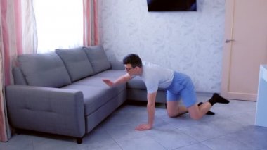 Komik nerd adam evde dört ayaklı ayakta germe fitness egzersizleri yapıyor. Spor mizah konsepti.