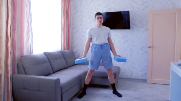 Der verspielte Nerd-Mann macht mühsam Übungen für den Handbizeps mit Yoga-Blöcken statt mit Kurzhanteln. Sport-Humor-Konzept. — Stockvideo