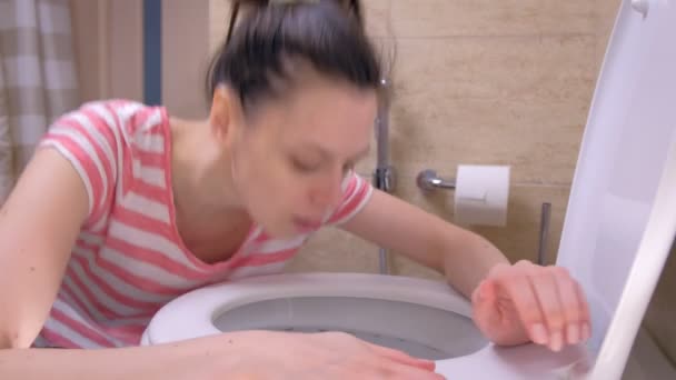 Wanita muda yang sakit menjalankan toilet untuk muntah duduk di lantai, gejala keracunan makanan . — Stok Video