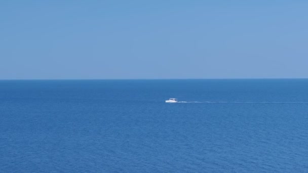 Λευκό μηχανοκίνητο σκάφος που πλέει στη θάλασσα την καλοκαιρινή ηλιόλουστη μέρα. — Αρχείο Βίντεο