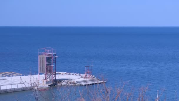 Breakwater com uma torre de resgate no mar em dia ensolarado . — Vídeo de Stock