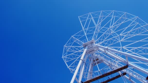 Conjunto de roda gigante no parque de diversões em fundo céu azul em dia ensolarado . — Vídeo de Stock