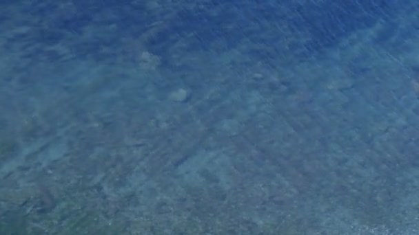 Acqua di mare trasparente blu con fondo in pietra e piccole increspature . — Video Stock