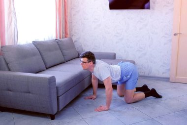 Komik nerd adam evde dört ayaklı ayakta geri için germe egzersiz yapıyor. Spor mizah konsepti.