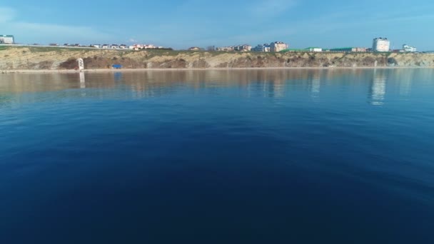 Piękne tło morskie z górami i nadmorskiego miasteczka, latające nad turkusową wodą w spokojnym morzu. — Wideo stockowe