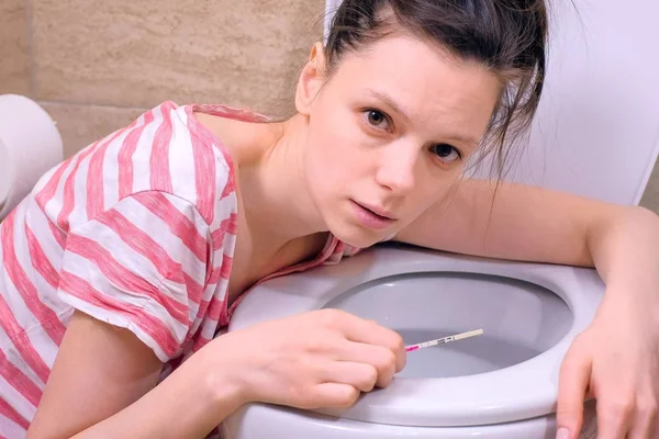 Ochtend ziekte. Jonge zwangere vermoeide vrouw is braken in toilet thuis lookin bij camera. — Stockfoto