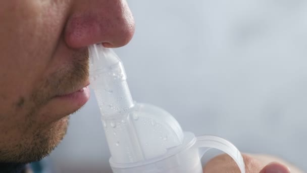 Bolnavul inhalează prin duza inhalatorului pentru nas. Nas de aproape, vedere laterală. Utilizați nebulizator și inhalator pentru tratament . — Videoclip de stoc