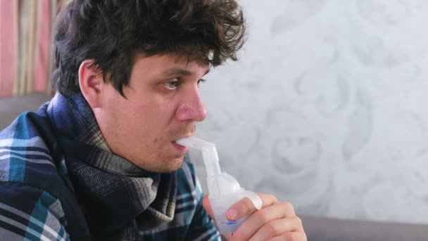 Vernevelaar en inhalator gebruiken voor de behandeling. Zieke man inademen via inhalator nozzle voor de keel. Close-up gezicht. — Stockvideo