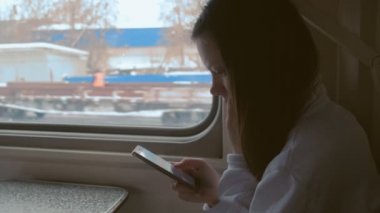 Cep telefonu video izlerken tren yorgun genç kadın.