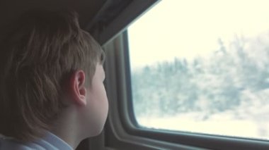 Çocuk tren kış manzara üzerinde hareketli penceresinde arıyor.