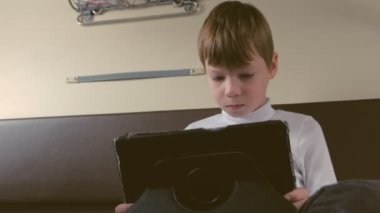 Çocuk trende bir tablet ikinci sınıf bir arabaya oynuyor