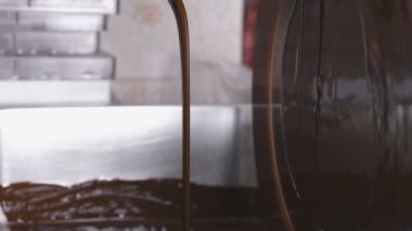 Sıcak sıvı makine temperleme çikolatada çikolata. Yakın çekim görünümü. Çikolata candys imalatı.