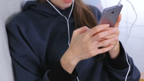 Woman types a message on a mobile phone, hands close-up. — Stock Video