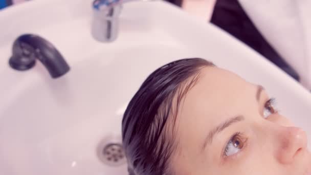 Barbier laver les cheveux des clients dans le salon de beauté dans l'évier . — Video