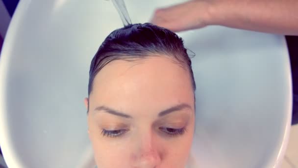 Парикмахер стирает клиентам волосы в салоне красоты в раковине . — стоковое видео