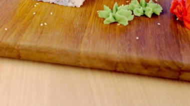 Ahşap pansiyon sause wasabi, zencefil ve soya ile balık ve susam tohumu ile rulo üst hizmet.