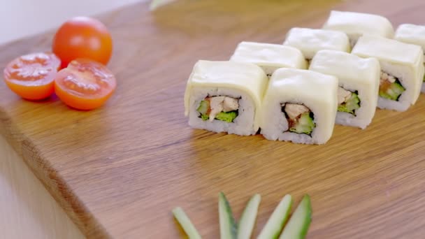 Brötchen mit Huhn, Gurke, Gemüse und Sahne auf Holzbrett mit Gemüse serviert. — Stockvideo