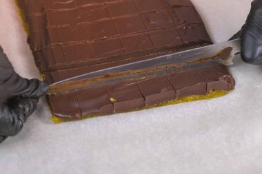 Bıçak kullanarak kayısı marmelat ile çikolata şekerpralin için kesme dolgular.