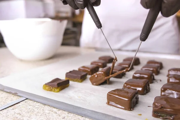 Production of chocolate candies. Hands close-up.